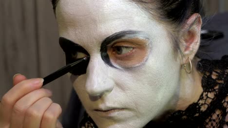 Mujer-con-lápiz-negro-rellenar-en-las-cuencas-oculares.-Concepto-de-ideas-de-maquillaje-de-Halloween