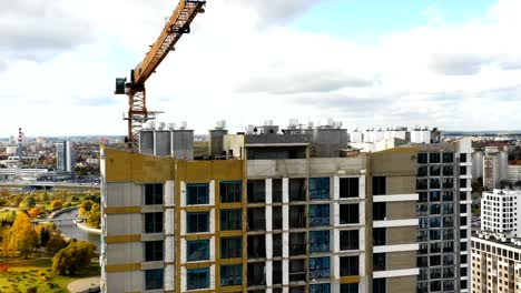 Drone-flying-large-tower-apartment-blocks-under-construction-revealing-majestic-National-Library-of-Belarus,-Minsk.