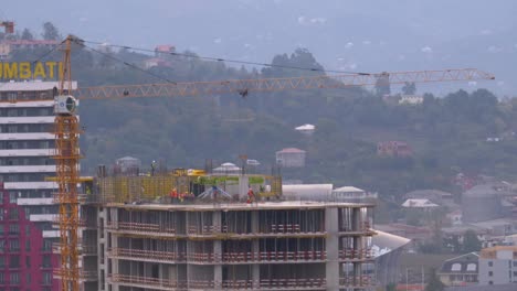 Trabajadores-en-una-obra-de-construcción.-Grúa-en-un-sitio-de-construcción-levanta-una-carga