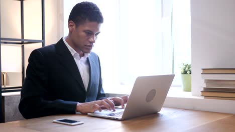 Schwarz-Geschäftsmann-verärgert-durch-Verlust-während-der-Arbeit-am-Laptop