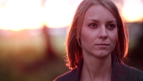 Portrait-of-beautiful-blonde-pensive-woman-outdoor-in-the-summer,-looking-into-the-distance-on-sunset,-close-up