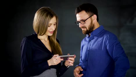 Business-Center.-Korridor.-Manager-in-der-Pause-zu-kommunizieren.-Ein-junges-Mädchen-zeigt-ihre-Freundin-video-auf-ihrem-smartphone