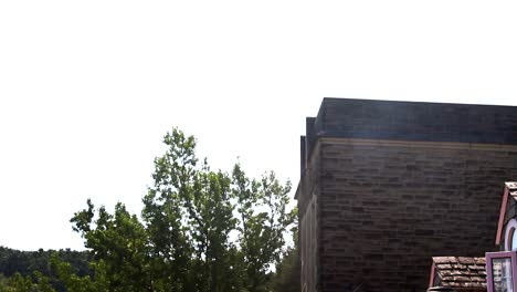 Establishing-shot-of-a-belltower-near-an-old-country-inn-in-summer