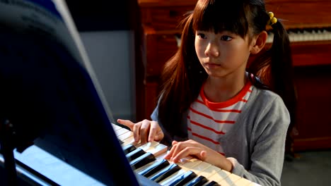 Schoolgirl-learning-electric-piano-in-music-class-4k