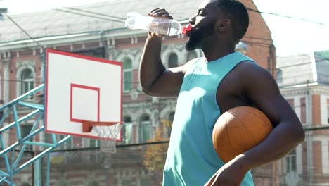 Sportsman-drinking-from-bottle,-restoring-water-balance-after-active-training