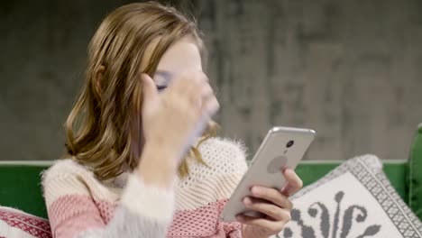 Teen-Girl-Chat-mit-Freund-per-Smartphone-zu-Hause