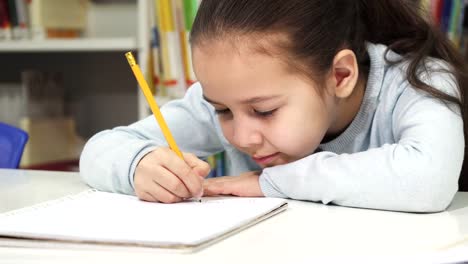 Adorable-little-girl-drawing-in-her-notebook