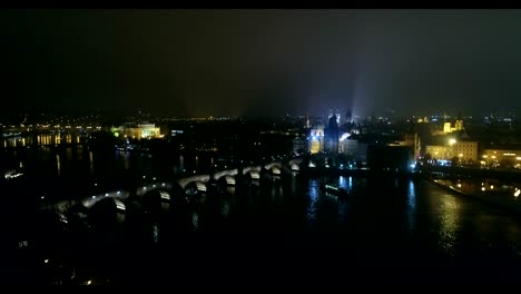 Night-panorama-of-Prague,-panoramic-view-from-the-air-to-the-old-town-and-Charles-Bridge,-lights-of-the-night-city,-Prague