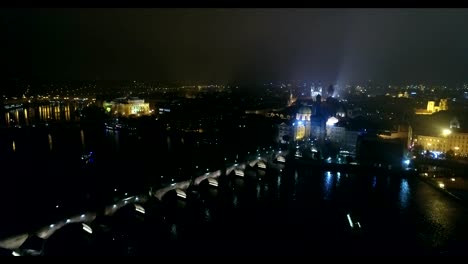 Night-panorama-of-Prague,-panoramic-view-from-the-air-to-the-old-town-and-Charles-Bridge,-lights-of-the-night-city,-Prague