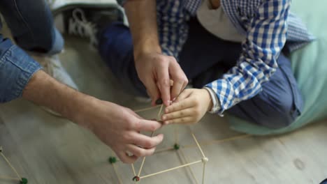 Maestro-y-niño-toma-casa-con-palillos-de-madera