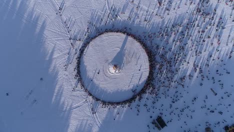 Circle-of-people-which-watch-burning-of-dummy-during-celebration-of-Russian-traditional-holiday-Maslenitsa.-Footage.-Aerial-view