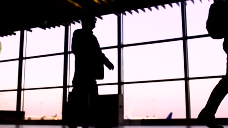 Silhouettes-of-busy-people-in-main-hall-of-airport,-illegal-immigration-problems