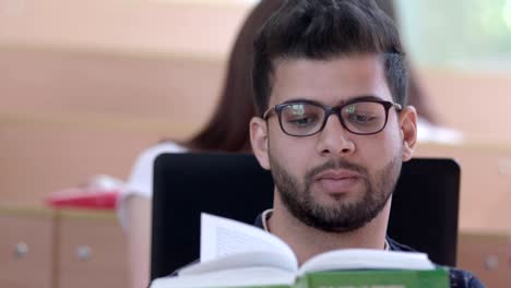 Student-with-a-beard-reading-during-university-class.