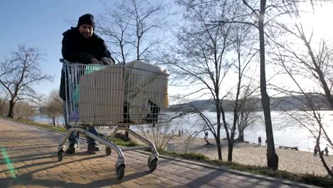 Front-view-of-homeless-mature-man-pushing-cart