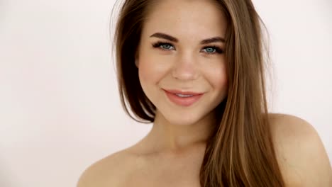 beautiful-blonde-girl-with-bare-shoulders-posing-against-a-white-wall-close-up