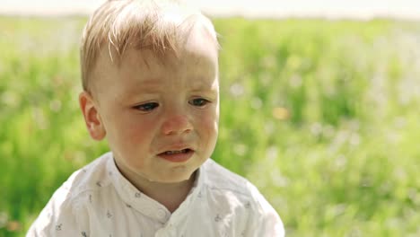 Little-boy-crying-in-park-in-city,-close-up