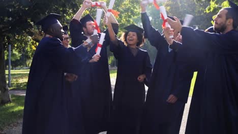 glückliche-Schüler-in-Mörtel-Boards-mit-Diplomen