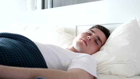 Close-Up-of-Disturbed-Man-Sleeping-in-Bed