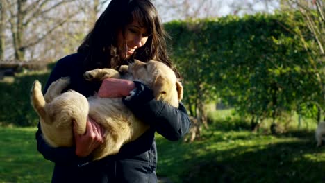 A-girl-cuddles-golden-retriever-puppy