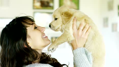 Eine-Mädchen-küsst-golden-Retriever-Welpe