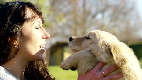 A-girl-kisses-golden-retriever-puppy