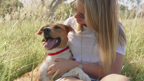 Young-woman-petting-loving-her-pet-dog-in-nature