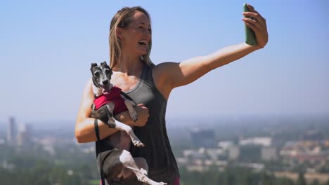 Slow-Motion-junge-passen-Frau,-die-malerischen-Selfies-auf-ihr-Handy-mit-ihrem-Hund