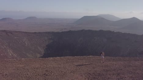 Mädchen-mit-ihrem-Hund-auf-dem-Gipfel-des-Vulkans,-fuerteventura