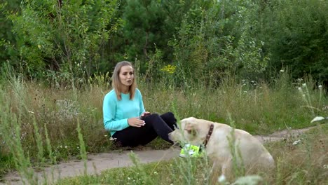 Mujer-joven-está-caminando-con-perro-en-el-bosque