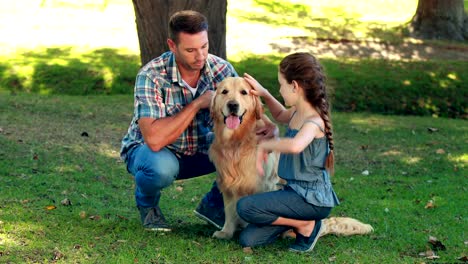 Padre-e-hija-con-una-mascota-perro-en-el-parque