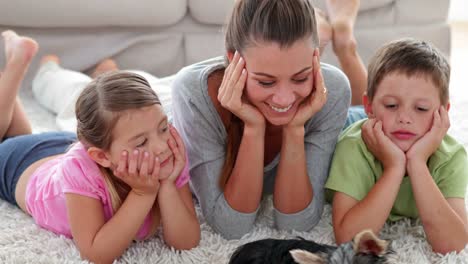 Siblings-playing-with-puppy-and-their-mother-on-the-rug