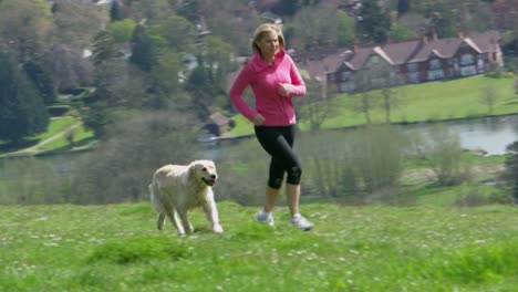 Mujer-madura-con-perro-a-correr-por-el-campo-de-tiro-en-R3D