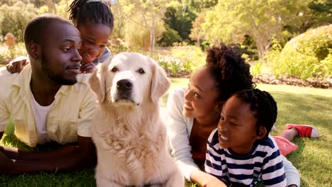 Linda-familia-es-tumbado-en-la-hierba-con-un-perro