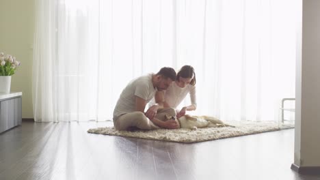 Pareja-jugando-con-perro-Shiba-en-sala-de-estar.