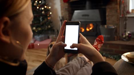 Mujer-en-línea-con-el-teléfono-móvil-en-habitación-listo-para-Navidad