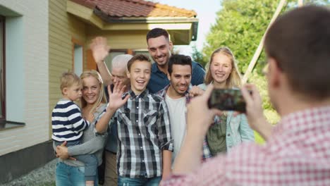 Hombre-tomando-fotos-al-aire-libre-de-su-gran-familia.