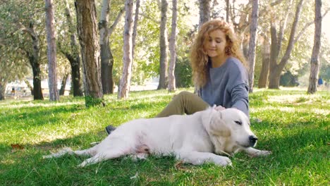 Junge-Frau-mit-Labrador-Retriever-Hund-im-Park-spielen