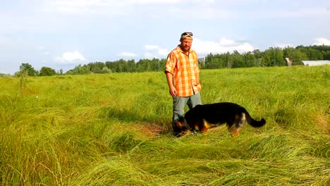 Mann-mit-seinem-Hund-auf-der-grünen-Wiese