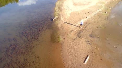 Frau-mit-ihrem-Hund-zu-Fuß-in-der-Nähe-Fluss-Küste-an-einem-sonnigen-Tag-4k