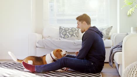 Young-man-sitting-on-ground-playing-with-his-pet-dog-4K-4k