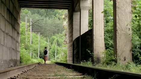 Young-girl-walks-on-the-reailway-in-the-tunnel