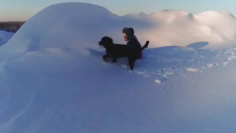 Niño-alegre-jugando-con-perro-en-la-nieve