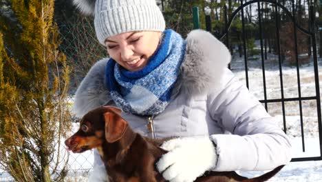 Frau-spielt-mit-ihren-kleinen-Hunden-draußen-winter