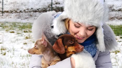 Frau-spielt-mit-ihren-kleinen-Hunden-draußen-winter