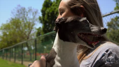 Slow-Motion-blonde-Frau-halten-und-küssen-ihr-italienisches-Windspiel-Hund-im-park