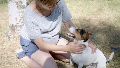 Frau-mit-ihrem-Hund-auf-dem-Rasen