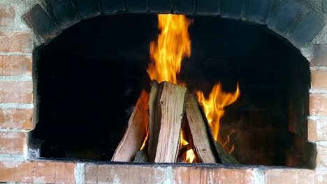 Fuego-de-una-chimenea-de-ladrillo-rojo-de-madera