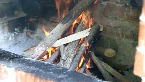 Fuego-de-una-chimenea-de-ladrillo-rojo-de-madera