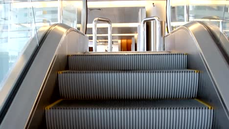 Empty-escalator-stairs-moving-up-with-logo-warning-in-modern-office-building