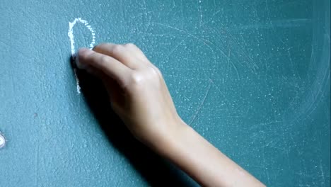 Child's-hand-writes-on-the-chalkboard-words-"Back-to-School!"